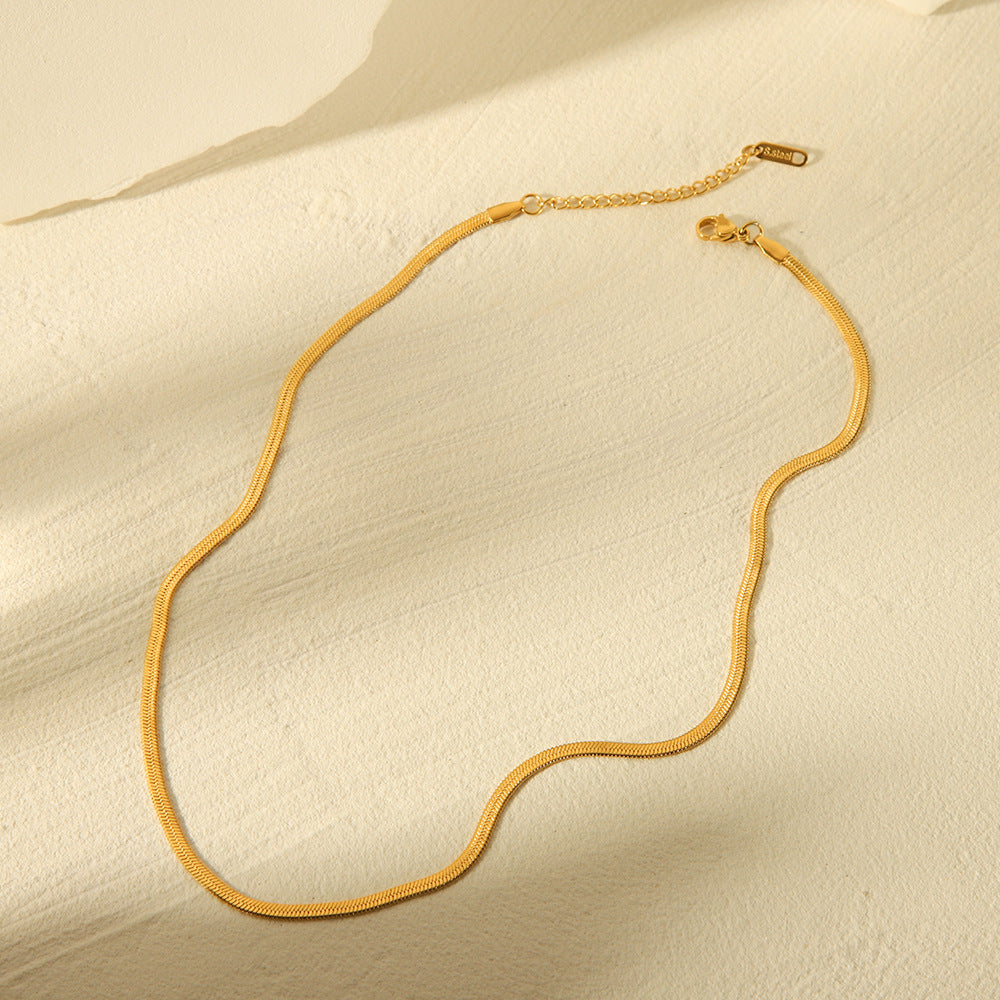 Flat lay 2 of the Cleo Gold Necklace arranged neatly, highlighting its polished 14k gold surface and closure design.