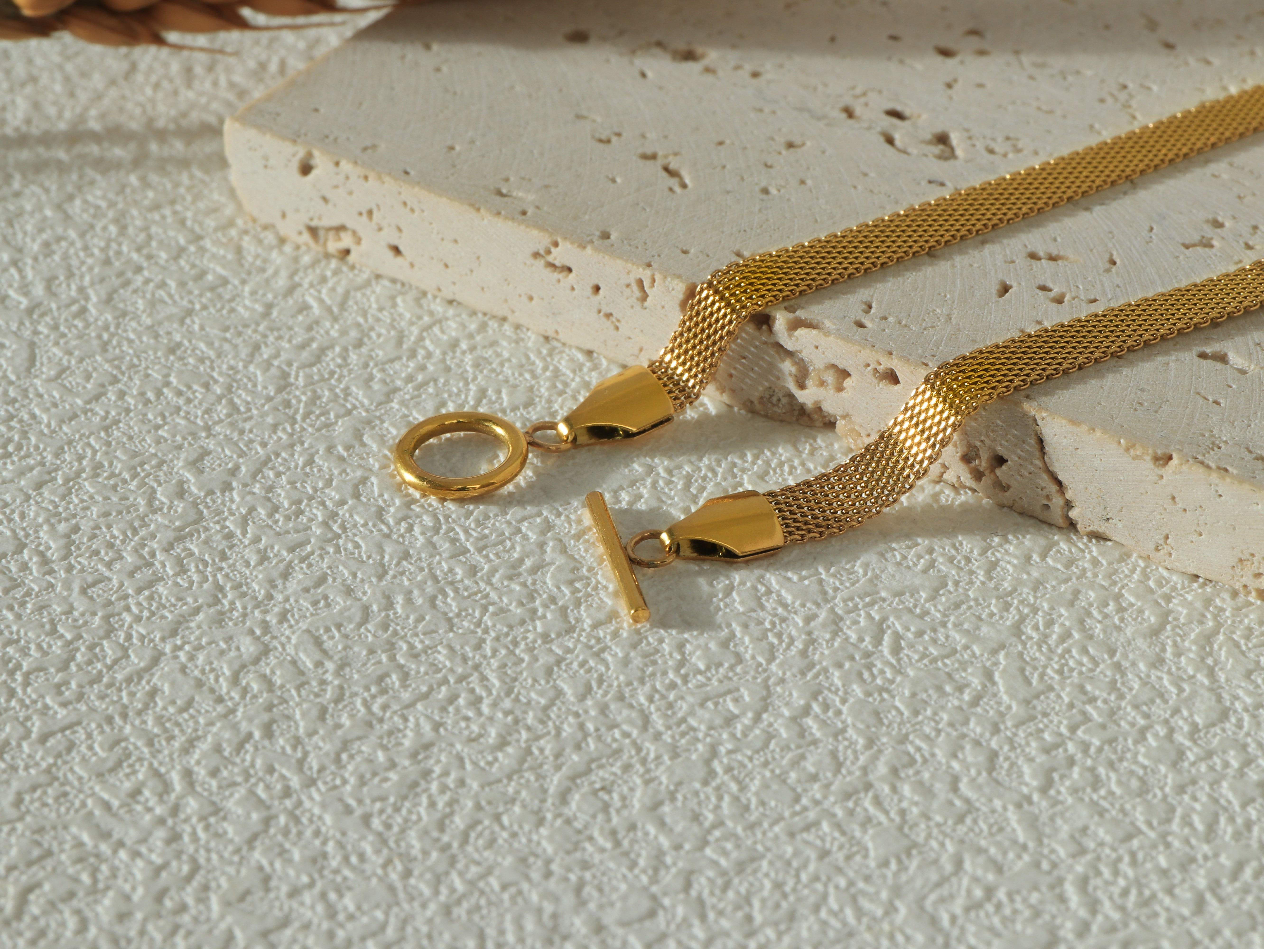 Detailed shot of the Dominion Necklace OT clasp, showcasing its unique, modern design and gold-plated stainless steel construction.