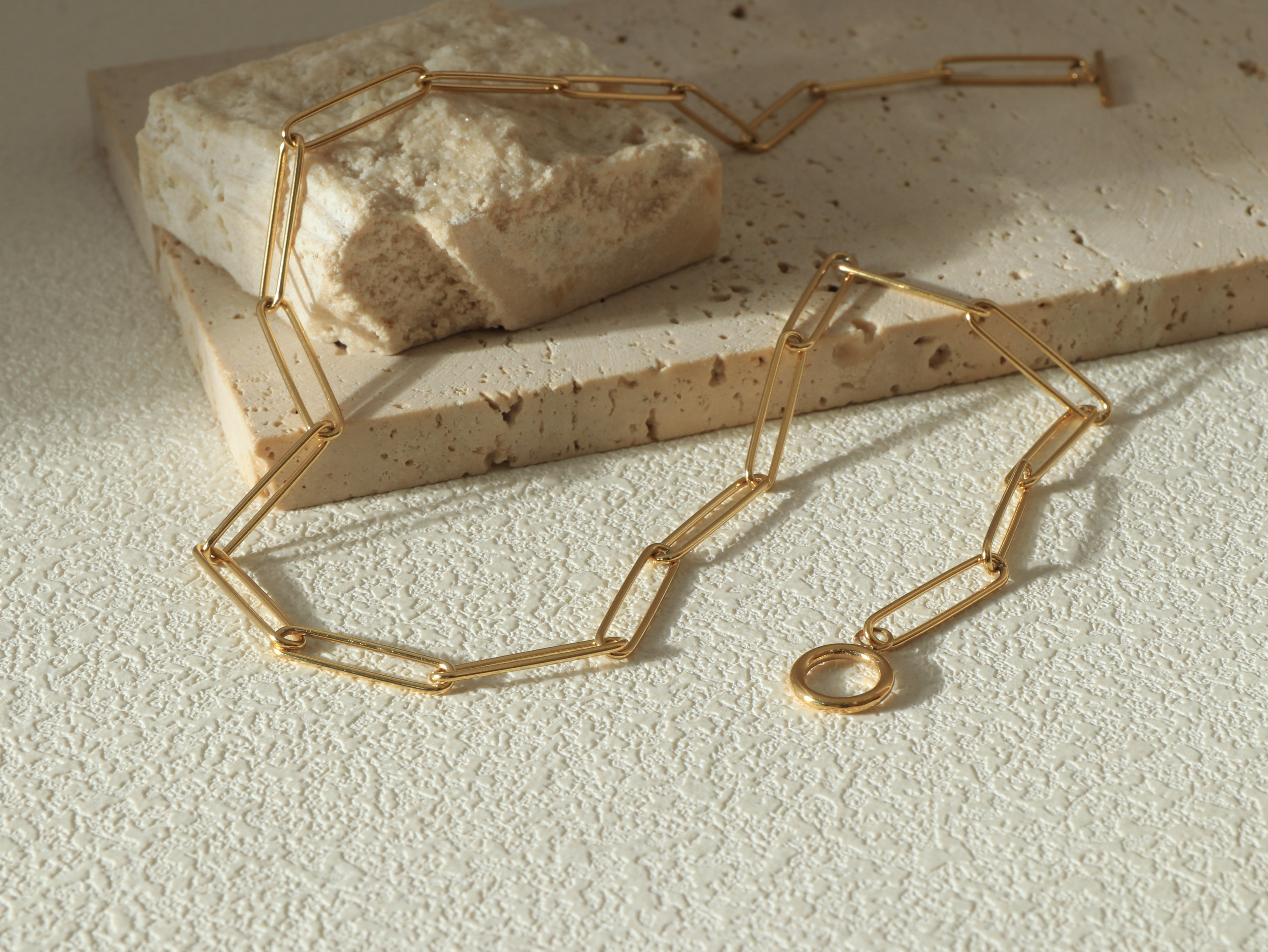 Full-length flat lay of the Unity Chain necklace, showing the stainless steel base and gold finish, designed for strength and elegance.