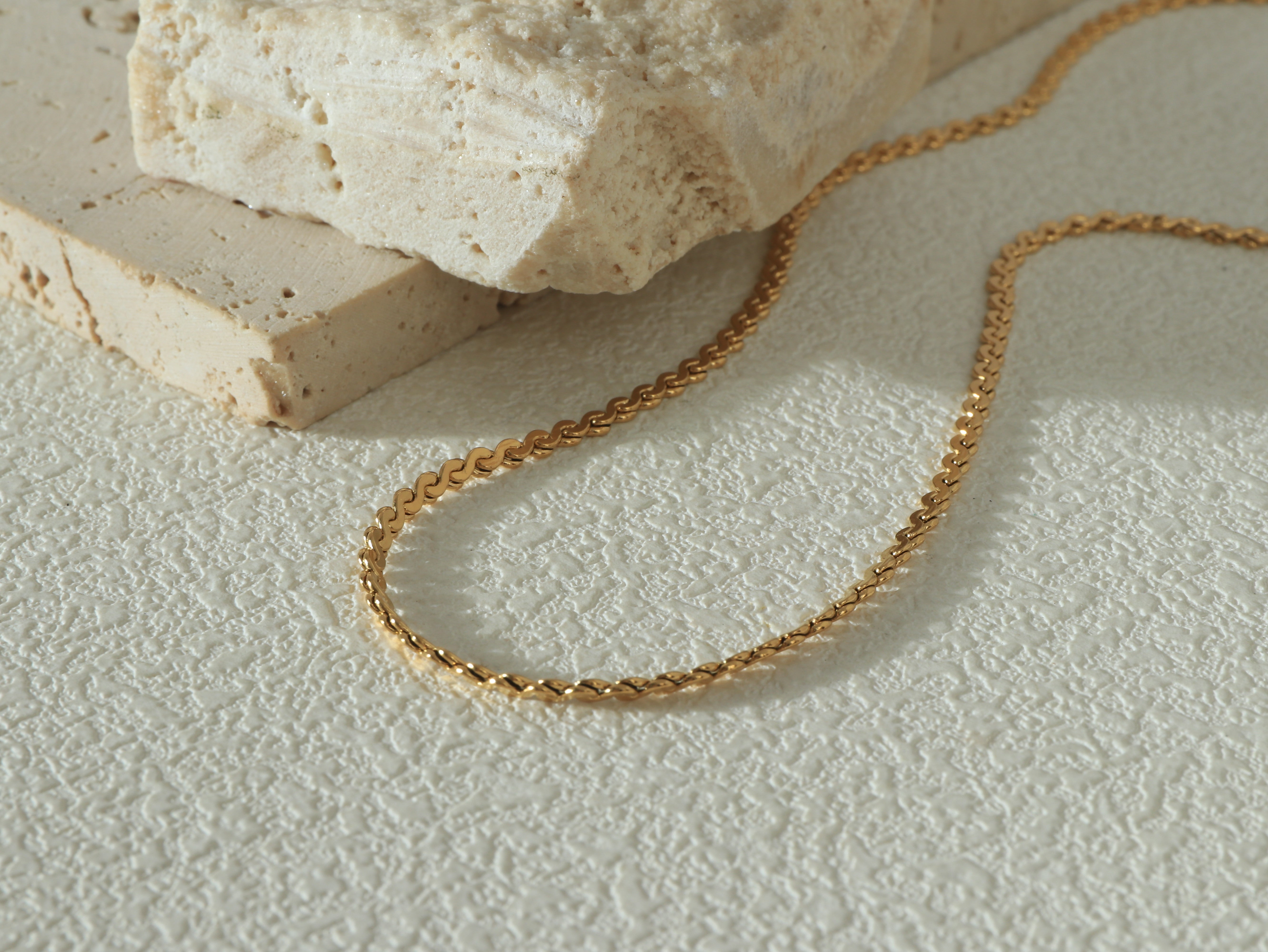 Close-up of the Allure Chain, showing smooth 18k gold-plated links, scratch-resistant surface, and waterproof stainless steel base.