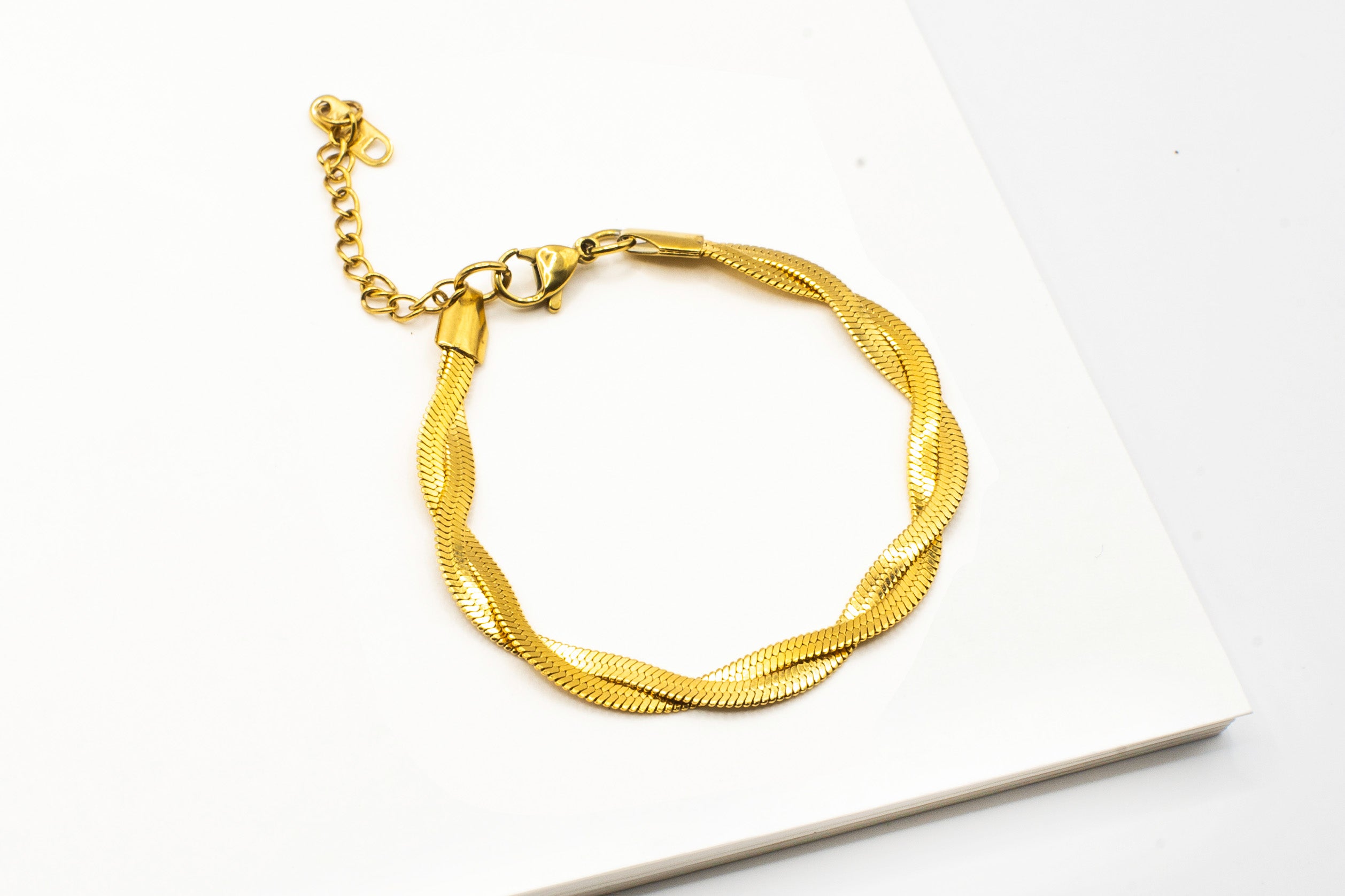 Empress Gold Bracelet in 18k real gold over stainless steel, displayed on a white background - striking twisted design - 16.5cm length with 3cm extension chain.