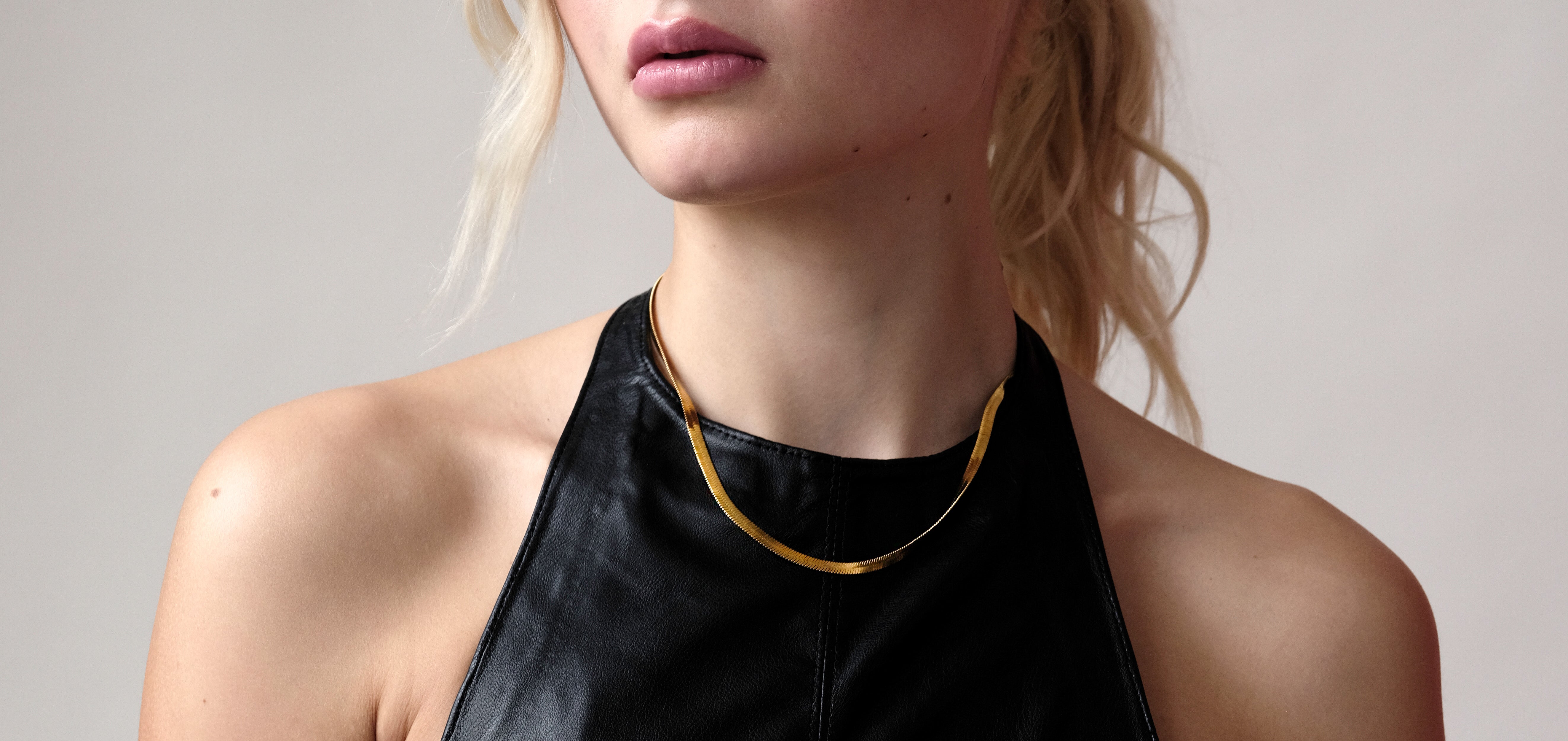 Cleo Gold Necklace worn by model, showcasing its sleek 14k gold finish and classic 3mm width, resting elegantly along the neckline