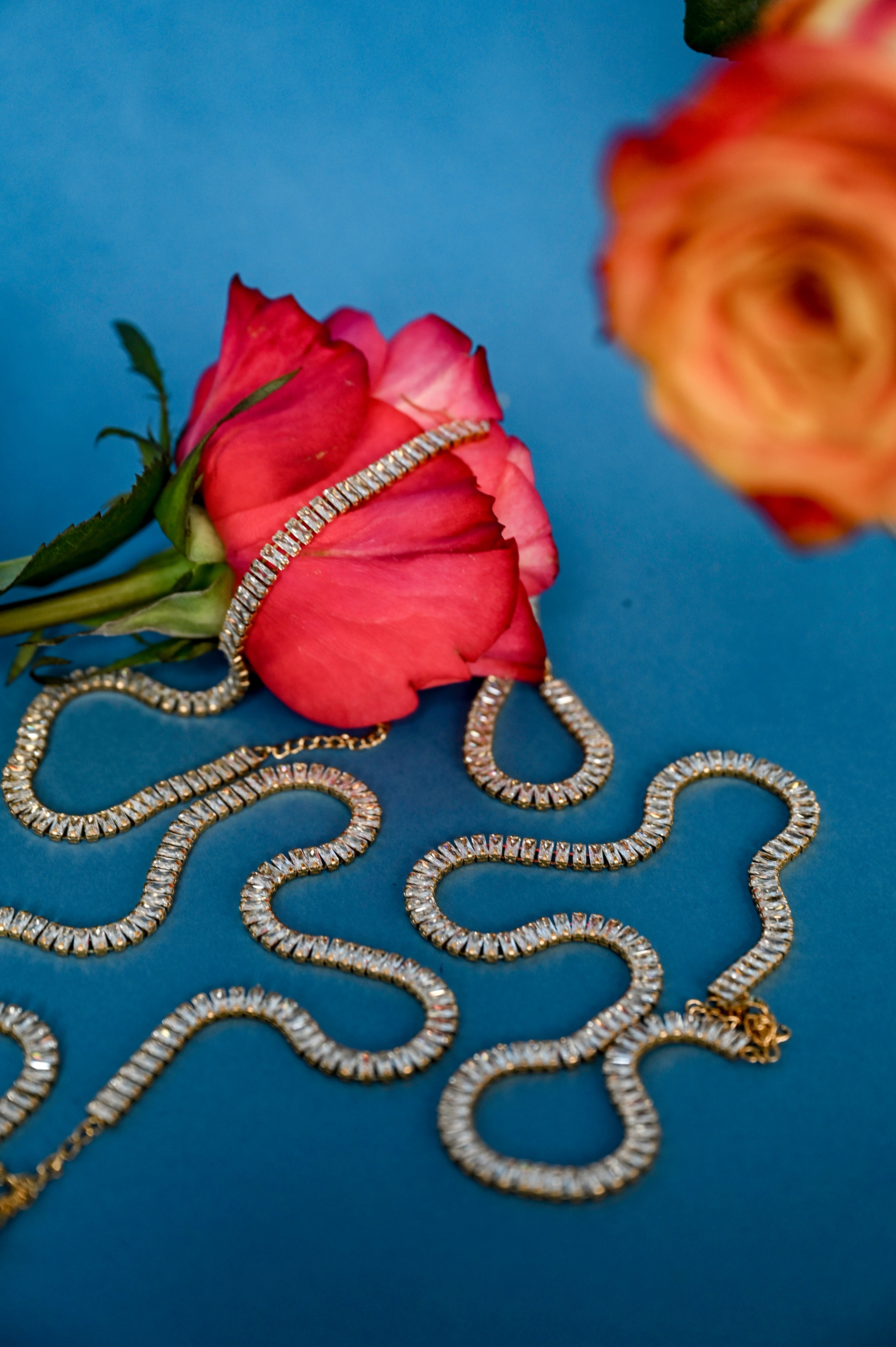 Lustre Gold Necklace styled on soft floral background, emphasizing its gold and crystal elegance against natural textures - Floral image 2