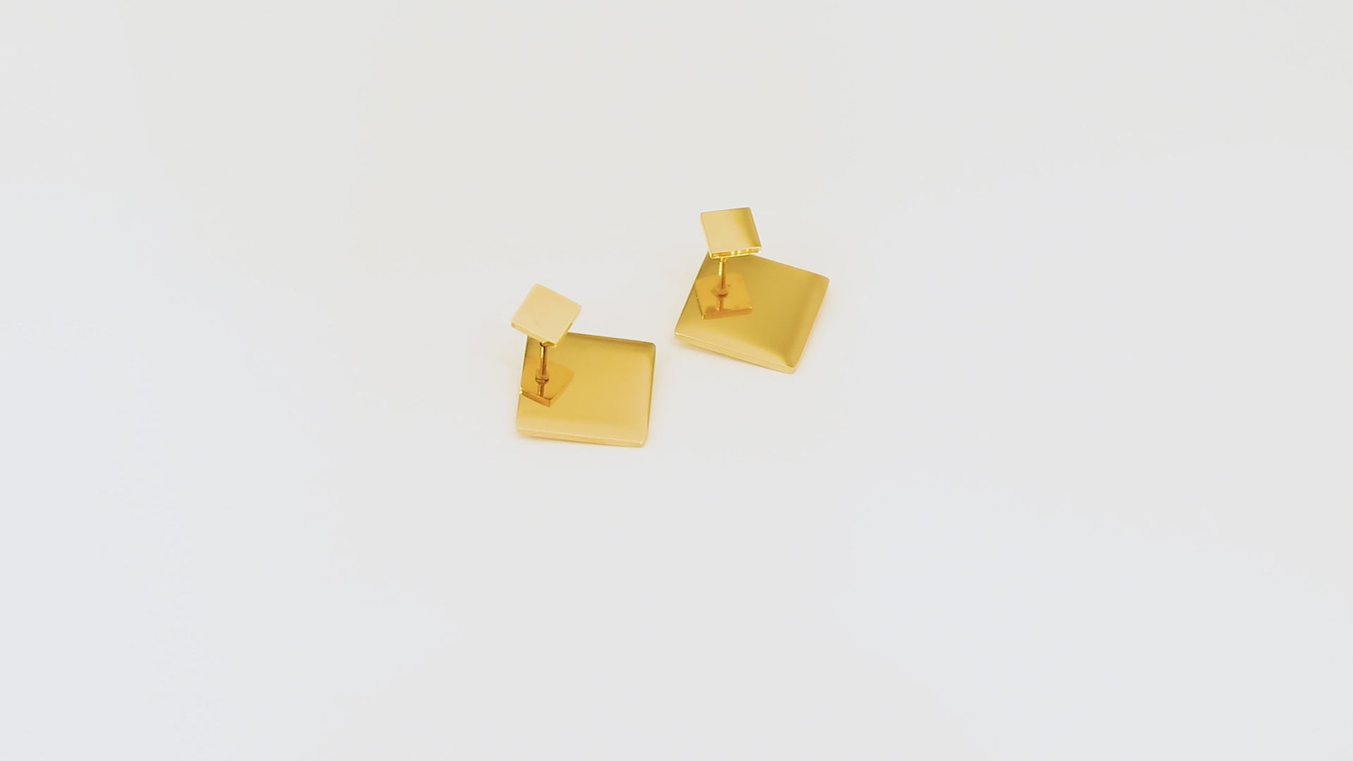 Video of Revolve Rhomb Earrings - 18k gold coated earrings with bold dual-size structure in motion.