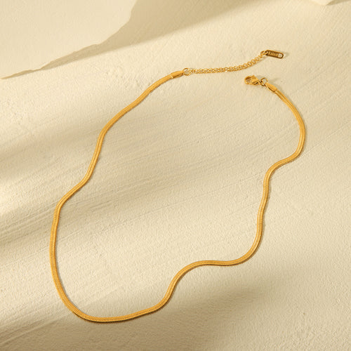 Flat lay 2 of the Cleo Gold Necklace arranged neatly, highlighting its polished 14k gold surface and closure design.