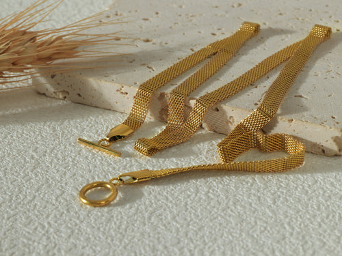 Dominion Necklace arranged in a soft curve, highlighting its elegant link shape, clasp design and gold shine.