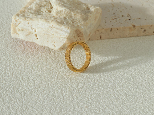 Full view of the Dominion Band in gold, standing upright, highlighting its 18k gold surface and durable, waterproof properties.