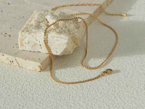 Allure Gold Chain arranged in a curved shape, showing its minimal, delicate design and waterproof gold coating - Image 1