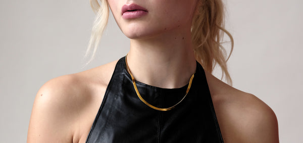 Cleo Gold Necklace worn by model, showcasing its sleek 14k gold finish and classic 3mm width, resting elegantly along the neckline