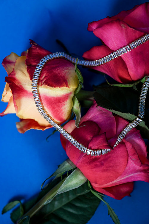 Lustre Gold Necklace styled on soft floral background, emphasizing its gold and crystal elegance against natural textures - Floral image 3