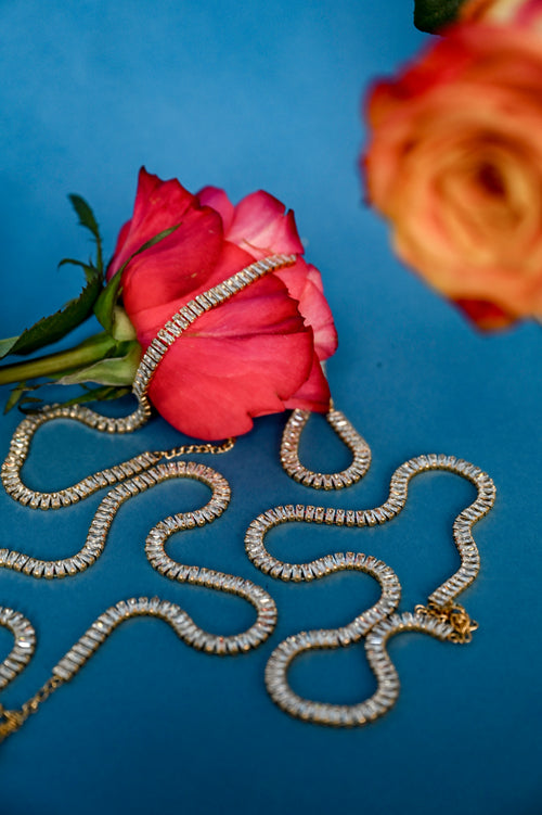 Lustre Gold Necklace styled on soft floral background, emphasizing its gold and crystal elegance against natural textures - Floral image 2
